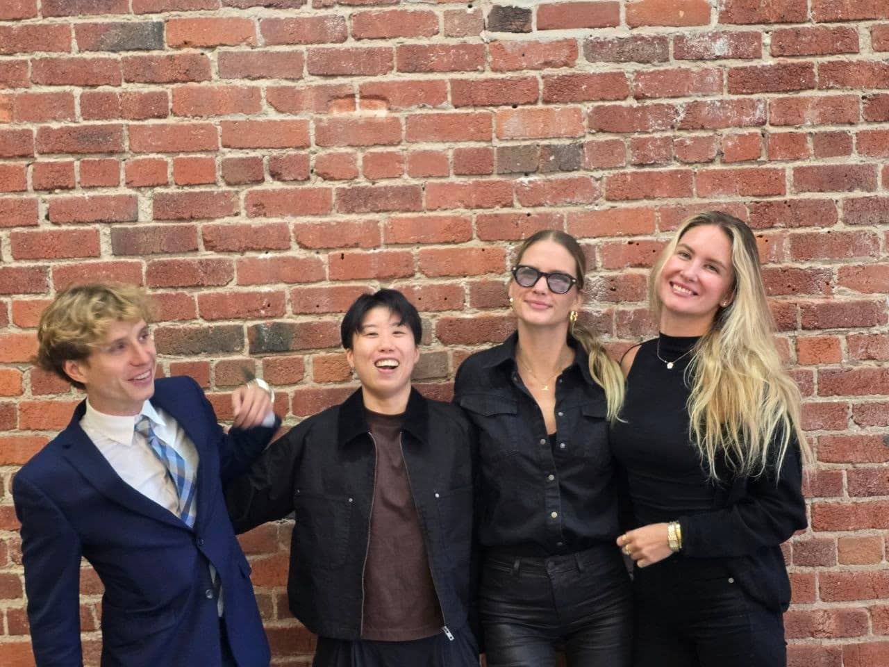 The team against the office brick wall